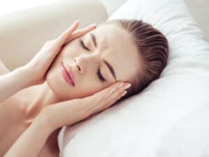 Vertigo Belirtileri Nelerdir? 1 Baş dönmesi ve vertigo nedeniyle yatakta dinlenen kadın , Vertigo Belirtileri Nelerdir?